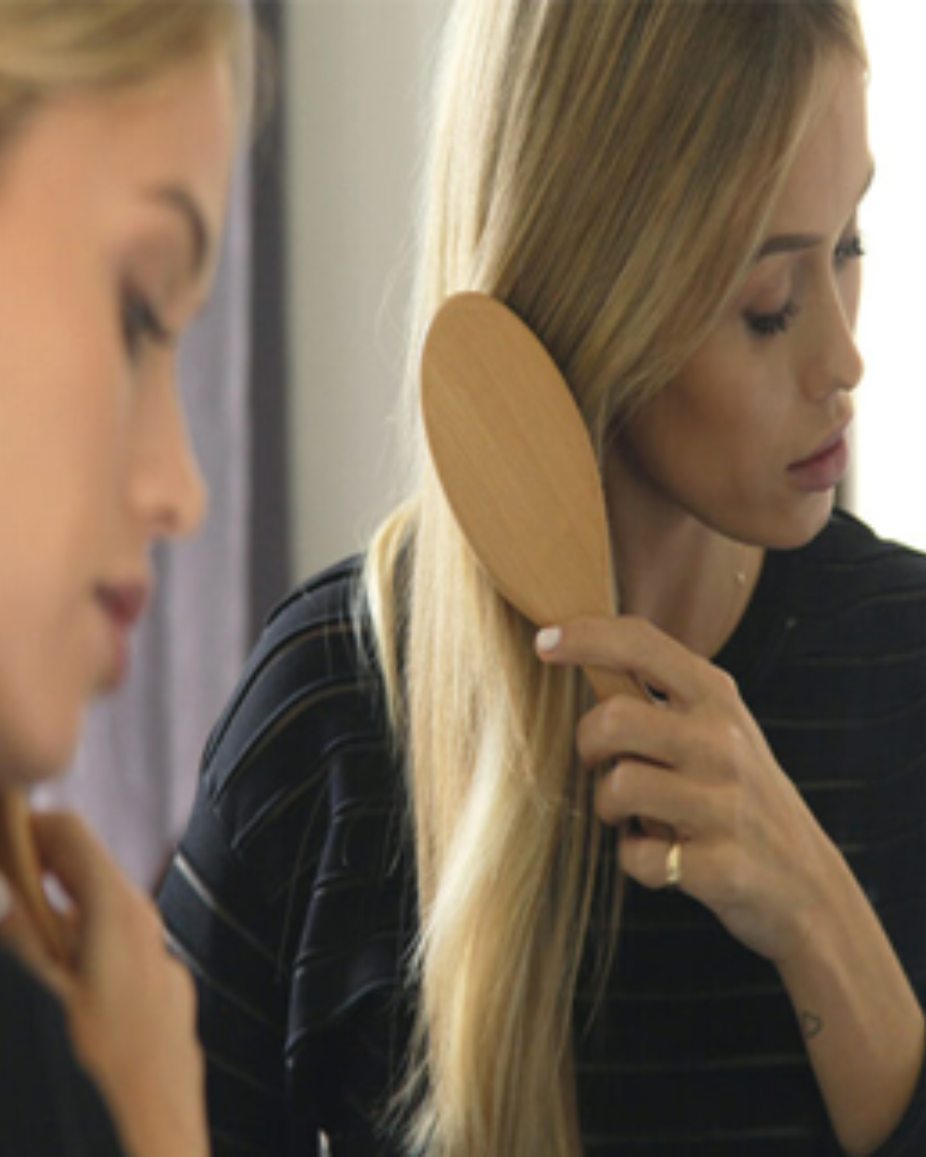 Woman examining dry damaged hair ends while learning what cosmetic hair repair can and cannot do.